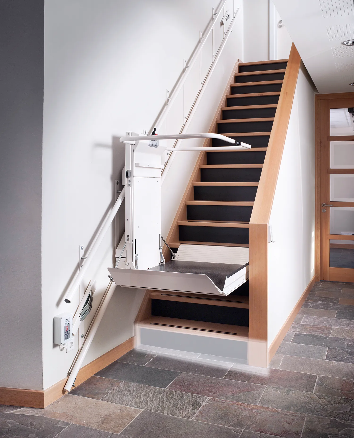 Plattformlift in Fahrtposition am Anfang der Treppe.